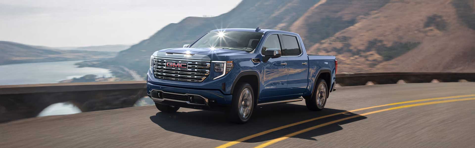 A blue Sierra 1500 running on road on road