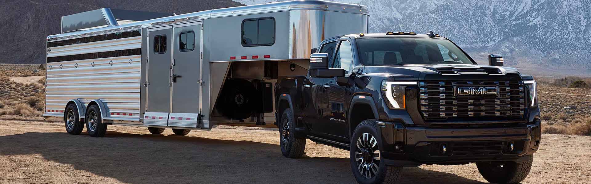 A black Sierra towing a container