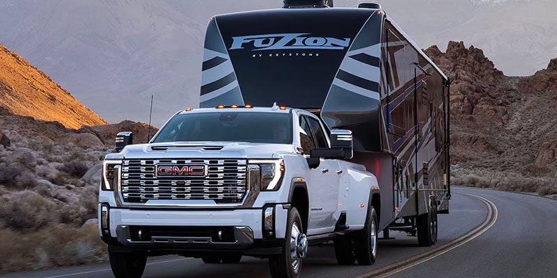 A White Sierra towing a bus