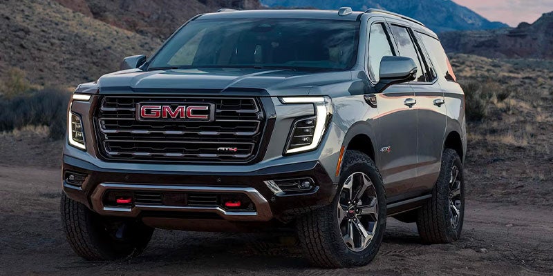 A Silver A black Yukon parked on ground front view
