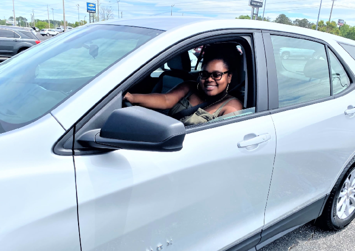 Woman driving new silver car at Glynn Smith Chevrolet Buick GMC